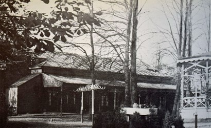 <p>Foto van voor 1891 van de houten concertzaal van de Buitensociëteit met rechts de houten muziektent (Looper 1991). </p>
